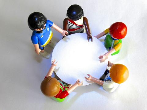 5 Playmobilfiguren an einem Tisch